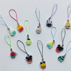 Puede incluir: Una colección de 12 abalorios de cupcake coloridos con diferentes diseños, que incluyen Mickey Mouse, una sirena y un pollito amarillo. Cada abalorio está unido a una cuerda, lo que los hace perfectos para agregar un toque de fantasía a bolsos, llaves u otros accesorios.
