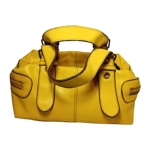 May include: A vibrant yellow handbag with a shiny surface. It has a top handle and two side handles, with brown detailing and zips. The bag is structured and has a roomy interior, suitable for daily use.