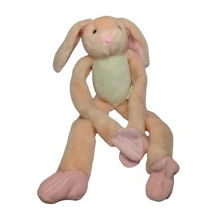 May include: A soft toy bunny rabbit in peach, pink, and light green. The bunny features long, floppy ears, a pink nose, and pink detailing on its feet and inner ears. The toy's arms and legs are elongated, giving it a playful look.