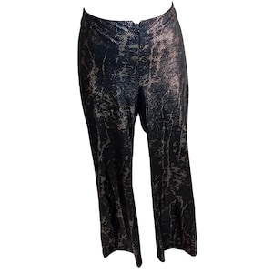 Op de afbeelding: Zwarte en bronzen broek met slangenpatroon. De broek heeft een hoge taille en een uitlopende pijp. De stof heeft een metallic glans en het patroon lijkt op slangenleer. Een stijlvolle toevoeging aan elke garderobe.