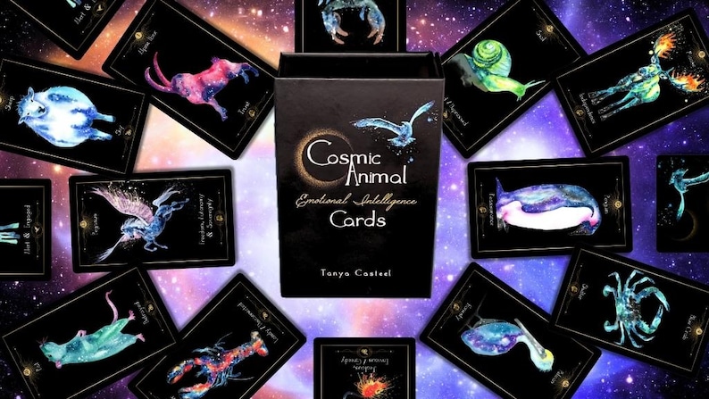 May include: A deck of "Cosmic Animal Emotional Intelligence Cards" with a black box and cards featuring watercolor animal illustrations. The cards are arranged around the box against a starry background. The box has the title and author's name.