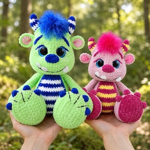 Puede incluir: Dos peluches de monstruos hechos de hilo suave. El monstruo más grande es de color verde lima con una barriga a rayas azules, pelo azul y cuernos azules. El más pequeño es rosa con una barriga a rayas amarillas, pelo rosa y cuernos amarillos.