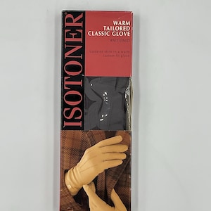 May include: A rectangular product box for Isotoner warm tailored classic gloves. The packaging features the brand name in large vertical black text, a red header with white text, and an image of tan gloves against a brown plaid fabric.