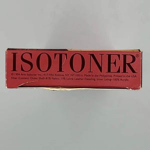 May include: A rectangular red product box with the brand name ISOTONER printed in large black capital letters. The box includes text detailing the 1994 copyright, address, manufacturing location, and fiber content of 81% nylon, 19% Lycra, and 100% acrylic.