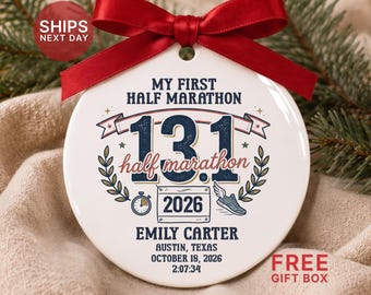 May include: A round white ceramic ornament featuring a red satin ribbon bow at the top. The design includes the text MY FIRST HALF MARATHON, 13.1, EMILY CARTER, AUSTIN, TEXAS, OCTOBER 18, 2026, 2:07:34, a stopwatch, a winged running shoe, and laurel leaves.