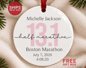 May include: A round white ceramic ornament with a red ribbon hanger. The text reads Michelle Jackson, 13.1, half marathon, Boston Marathon, July 7, 2026, and 4:08:20. The number 13.1 is printed in large light pink font across the center.