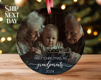 May include: A round, blue and white Christmas ornament with a photo of grandparents and a grandchild. The ornament has the text "First Christmas as grandparents 2024" and the logo "Simple Joy Studio".
