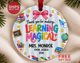 May include: A round ceramic ornament with a light blue striped background, featuring a pink bow at the top and the text Thank you for making LEARNING MAGICAL, MRS. MONROE, FROM, JESSICA, 2026, surrounded by colorful school supply illustrations.