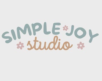 May include: The words "SIMPLE * JOY" in teal and "studio" in tan, with small pink flower accents, are arranged in a curved design on a white background. The design has a whimsical, handcrafted feel.