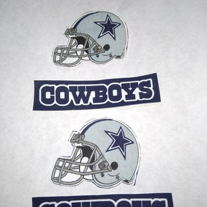 May include: Two iron-on patches featuring the Dallas Cowboys logo. The logo is a silver football helmet with a blue star on the side. The word "COWBOYS" is printed in blue letters on a navy blue background.