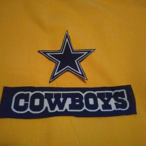 May include: A blue and white patch with a five-pointed star and the word "COWBOYS" on a yellow background.
