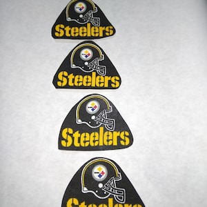 May include: Four black and yellow iron-on patches featuring the Pittsburgh Steelers logo and the word "Steelers" in yellow lettering.