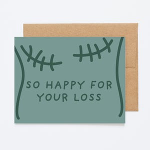 May include: A teal greeting card with the text "SO HAPPY FOR YOUR LOSS" in a playful font. The card features stitched-like illustrations. A brown envelope is behind the card.