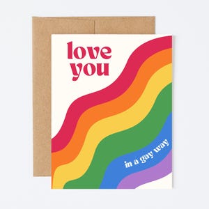 May include: A white card with a rainbow design and the text "love you in a gay way".