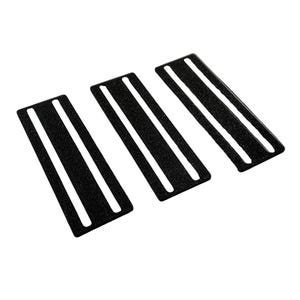 May include: Three black rectangular objects with white stripes. The objects have a textured surface and are arranged diagonally across the frame. The background is plain white.