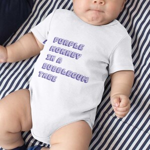 May include: White baby grow with purple text that reads "Purple Monkey in a Bubblegum Tree".
