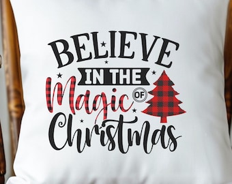 May include: White square pillow with the words "BELIEVE IN THE Magic OF Christmas" in black script. The word "Magic" is in red and black plaid. A plaid Christmas tree is on the right.