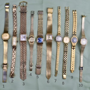 May include: A collection of ten vintage gold-toned wristwatches with various band styles. The watches feature different face shapes, including square, rectangular, and round. Some bands are mesh, while others have intricate link designs. The watches are displayed on a light green surface.