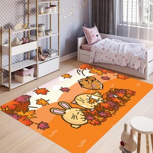 May include: An orange cartoon rug featuring a bunny, a cat, and a bear in a fall scene with colorful leaves. The rug is in a child's bedroom with a white bed, shelves, and a polka-dot wallpaper.