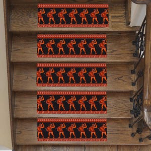 May include: Set of five red and black stair treads with a repeating pattern of warriors holding shields and swords. The treads are designed to be placed on stairs to prevent slipping.
