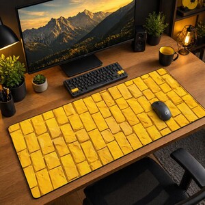 Può includere: Un tappetino per mouse a forma di strada di mattoni gialli con bordo nero. Il tappetino presenta un motivo ripetuto di mattoni gialli. Un mouse per computer nero è appoggiato sul tappetino. Una tastiera e un monitor per computer neri sono visibili sullo sfondo.