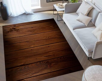 May include: A brown wood-look area rug with a dark brown wood grain pattern. The rug is laid out on a light wood floor in a living room setting.