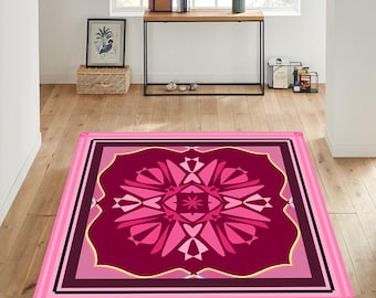 May include: Pink and burgundy area rug with a geometric pattern. The rug has a square shape with a large, intricate design in the center. The design features a repeating pattern of pink and burgundy shapes.