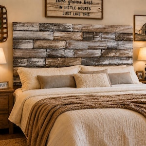 May include: A rustic headboard made of horizontal weathered wooden planks with a distressed finish, positioned behind a bed featuring a cream-coloured quilted coverlet, a chunky knit tan throw blanket, and several rectangular throw pillows.