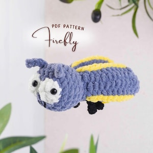 May include: A handmade crochet firefly toy in shades of blue and yellow. The plush insect has large white eyes with black pupils, a rounded body, and small black legs. The text "PDF PATTERN Firefly" is written in a script font.