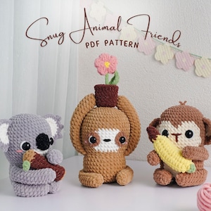 May include: Three crocheted animal figures: a grey koala holding a carrot, a brown sloth with a flower, and a brown monkey with a banana. The text "Snug Animal Friends PDF Pattern" is at the top.