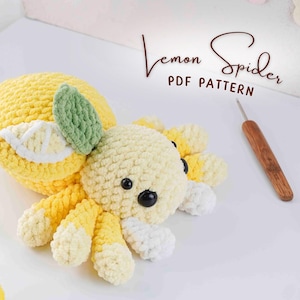 May include: A handmade crochet lemon spider toy with a yellow body, white and yellow legs, and black eyes. The spider has a green leaf and a lemon slice detail. The text "Lemon Spider PDF Pattern" is visible.