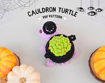 May include: A crocheted purple turtle with a black cauldron on its back. The cauldron is filled with green and orange yarn. The turtle is wearing a black witch hat. The image includes the text "CAULDRON TURTLE PDF PATTERN".