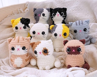 May include: A collection of nine crocheted cat plushies in various colors and patterns, including white, gray, brown, black, and yellow. The plushies have black eyes and pink noses.