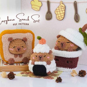 May include: A crochet "Capybara Snack Set" featuring a capybara design. The set includes a toast-shaped item, a cupcake, and a drink cup, all with capybara faces. The text "Capybara Snack Set PDF Pattern" is visible.