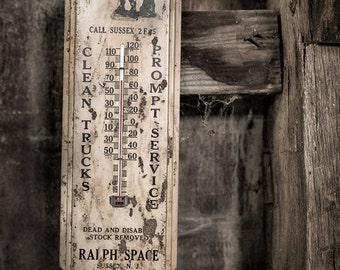 May include: A vintage, rusty metal thermometer with a black horse silhouette and the text "We Buy Old Horses". The thermometer has a white background with black text and numbers. The thermometer reads "Clean Trucks Prompt Service" and "Dead and Disab Stock Removed" with the business name "Ralph Space" and contact information.