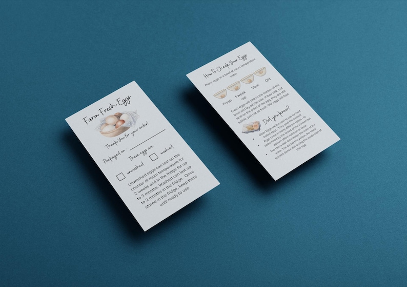 K&ouml;nnte beinhalten: Zwei wei&szlig;e Karten auf einer blauen Oberfl&auml;che. Eine Karte tr&auml;gt die Aufschrift "Farm Fresh Eggs" mit einer Illustration von Eiern. Die andere Karte tr&auml;gt die Aufschrift "How to Check Your Eggs". Beide Karten enthalten Text &uuml;ber die Lagerung und Frische von Eiern.