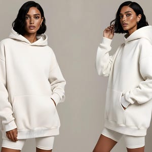 May include: Two images of a person wearing a cream-colored hoodie with a kangaroo pocket and matching shorts. The hoodie has a drawstring hood and ribbed cuffs and hem. The outfit is a casual, comfortable style.