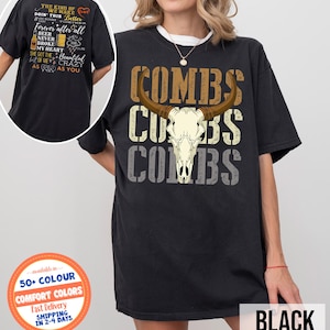 May include: Black t-shirt featuring a bull skull graphic with the word "COMBS" stacked three times. The shirt also has text on the back. The shirt is available in 50+ colors and comfort colors.