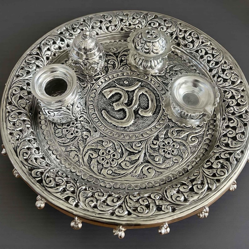 11-inch Om Pooja Thali Set in antique silver-plated brass featuring a central Om motif, Kalash, Agarbatti stand, and Kumkum box for Laxmi Puja 2026.