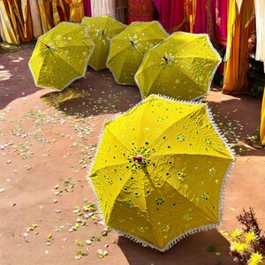 Yellow umbrella adorned with intricate mirror work and embroidery, ideal for Haldi and Mehendi decorations