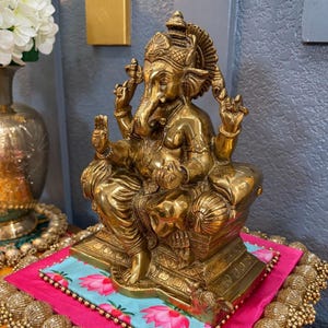 Detailed shot of engraved patterns on antique gold Brass Ganesha statue — handcrafted Indian art