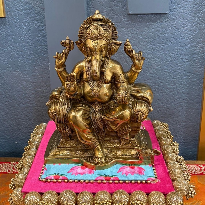 9.5" Brass Ganesha Statue antique gold finish on pink-blue platform — handcrafted Ganesh idol for home decor