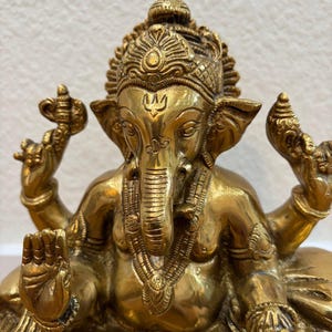 Close-up of finely engraved 9.5" Brass Ganesha statue showing intricate headdress and carved details