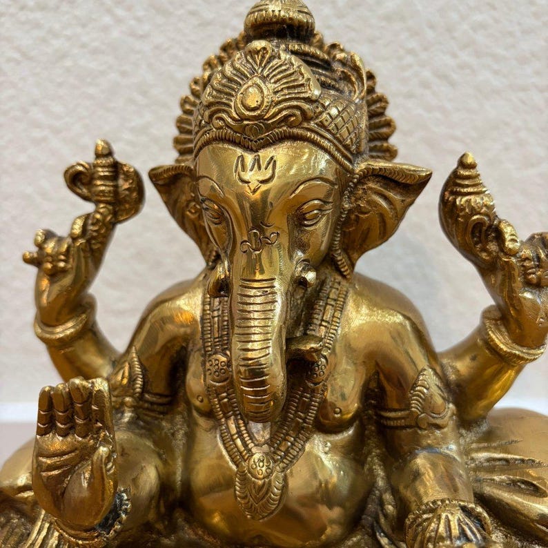 Close-up of finely engraved 9.5" Brass Ganesha statue showing intricate headdress and carved details