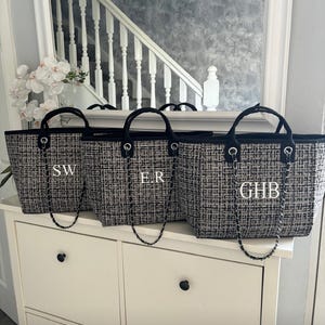 May include: Three black and white tweed tote bags with black chain straps and white monogram initials. The initials are "SW", "ER", and "GHB".