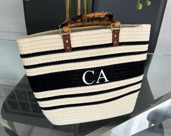 May include: A black and white striped tote bag with a bamboo handle and the initials "CA" embroidered on the front.