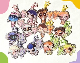 Può includere: Una collezione di portachiavi in acrilico colorati con personaggi dei cartoni animati e ciondoli a forma di stella e orso. I portachiavi presentano vari personaggi con design unici e colori vivaci, perfetti per i fan delle serie animate.