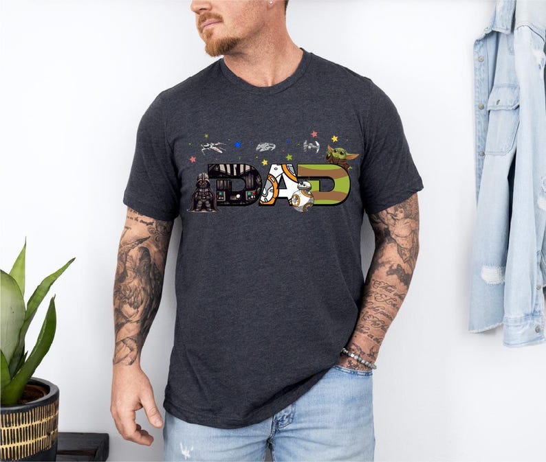 A man wearing a black t-shirt with a graphic design featuring the word "BAD" and various Star Wars and Star Trek characters.