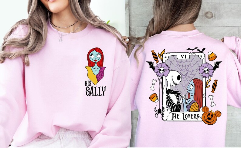 two pink sweatshirts with different designs. The left sweatshirt features a cartoon character, while the right sweatshirt has a tarot card design with a skeleton and a pumpkin.