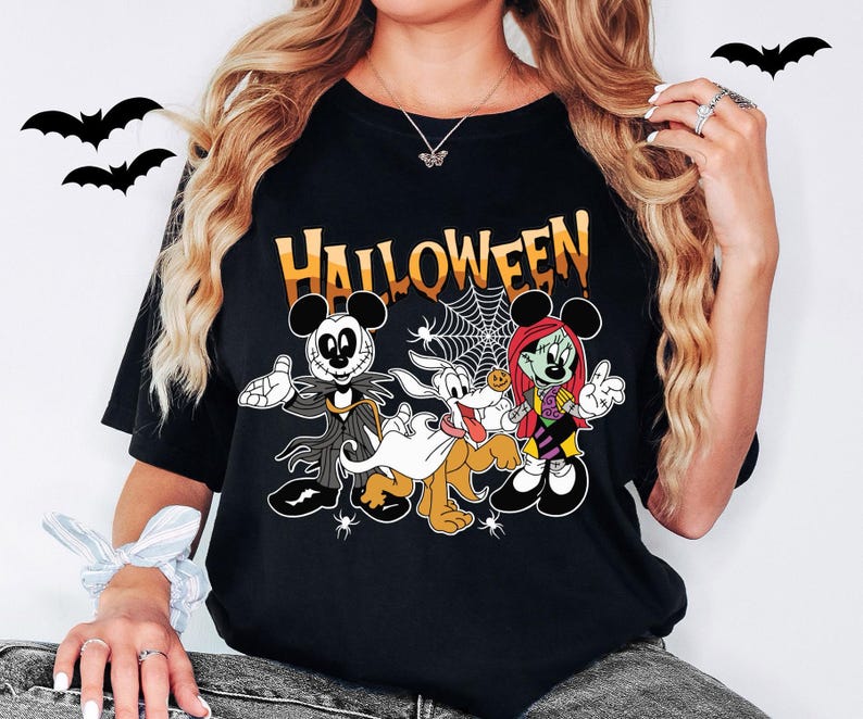 A woman wearing a black t-shirt with a Halloween-themed graphic design featuring characters from the Disney movie " jack Skellington and the Ghostly Dog".